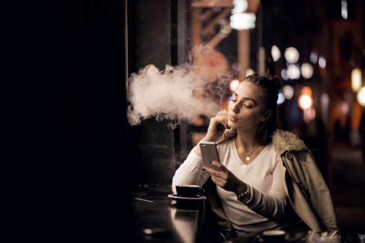 femme qui fume et sur son téléphone
