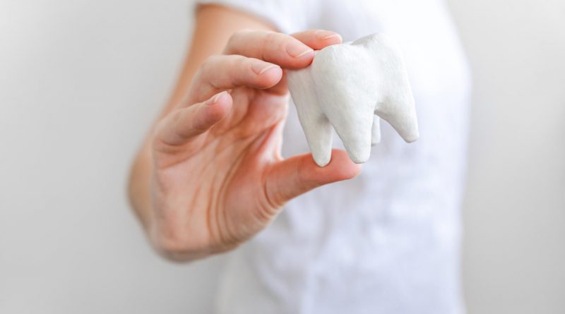 dentiste qui tient une dent