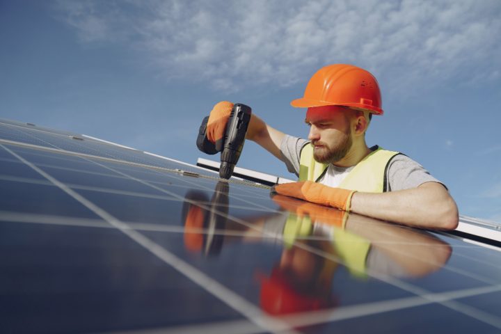 un ouvrier qui vis un panneau solaire