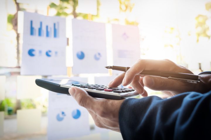un homme calculant quelque chose avec une calculatrice