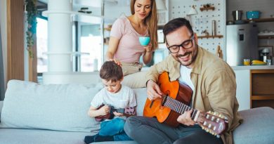 Homme qui joue de la guitare en famille