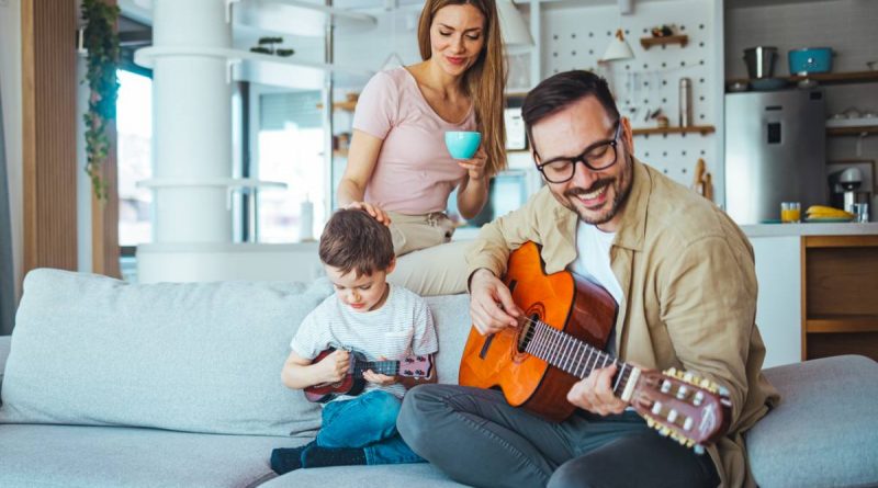 Homme qui joue de la guitare en famille