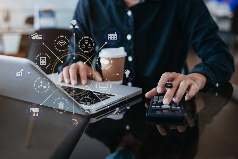 homme avec son pc et une calculatrice