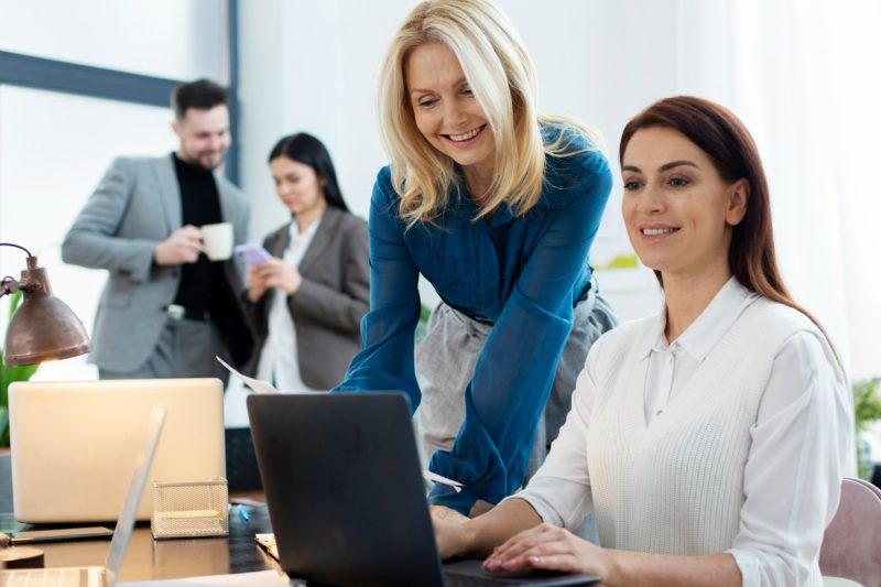 deux femmes au travail regarde l'écran de pc