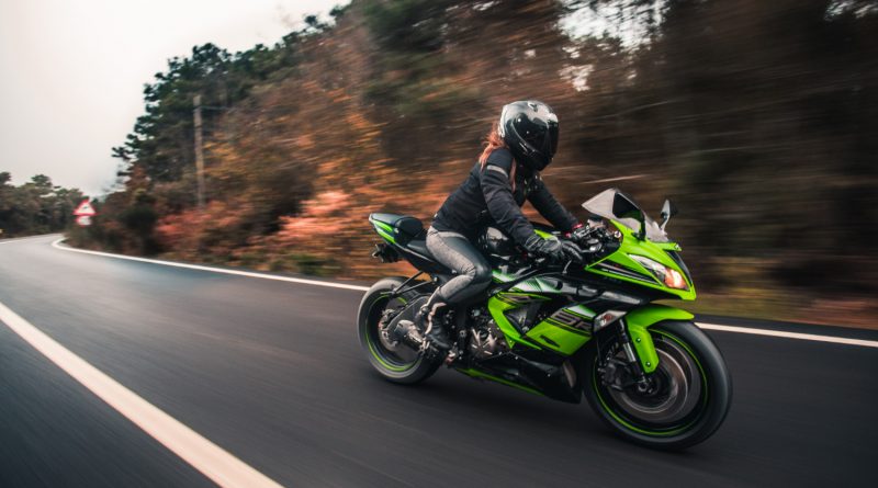femme roule sur une moto verte