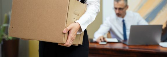 une femme portant son carton de déménagement de son bureau