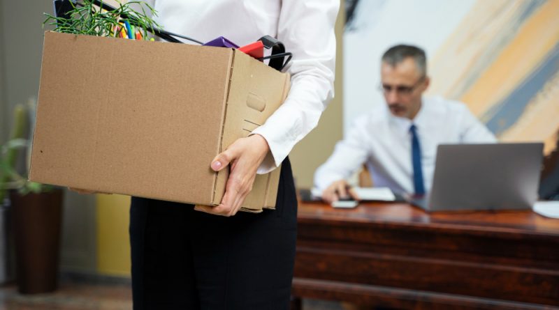une femme portant son carton de déménagement de son bureau