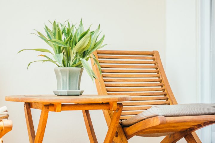 une chaise de jardin a côté d'une table avec une plante