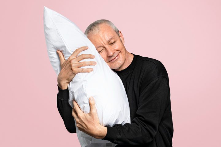 un homme calinant un oreiller