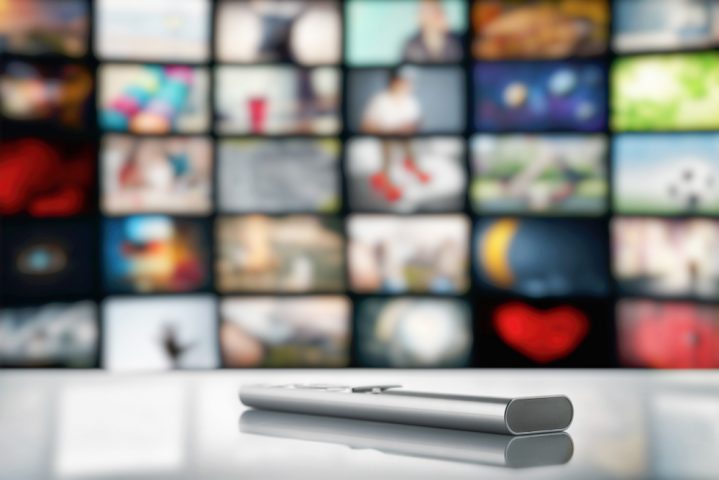 télécommande face à plusieurs écrans